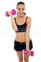 Smiling fit woman working out with dumbbells