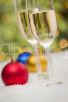Christmas Ornaments and Champagne Glasses on Snow