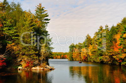 Fall Folliage and a lake with a boat.