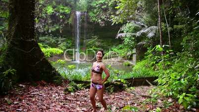 Sexy dancer on waterfall in rainforest