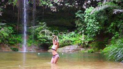 Sexy dancer on waterfall in rainforest