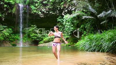 Sexy dancer on waterfall in rainforest