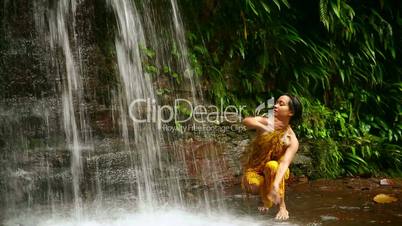 Sexy dancer on waterfall in rainforest
