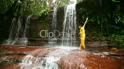 Sexy dancer on waterfall in rainforest