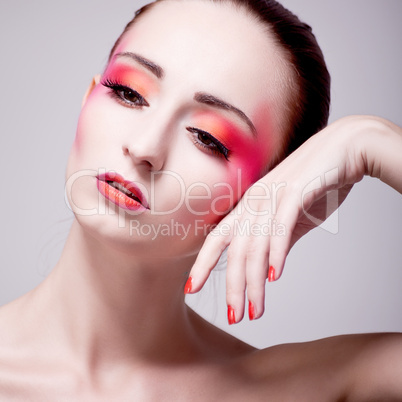 Junge Frau mit extremem makeup in rottönen portrait
