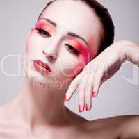 Junge Frau mit extremem makeup in rottönen portrait