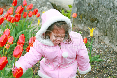 cute girl cut bouquet of red tulips on spring