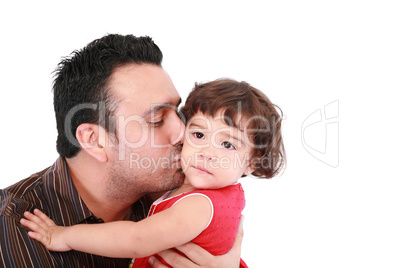 Father hugging and kissing little daughter, smiling.