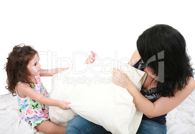 mother and daughter having fun with pillows