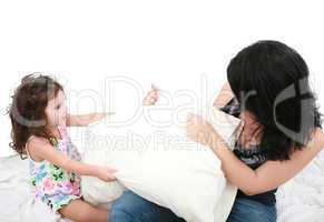 mother and daughter having fun with pillows