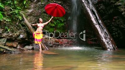 Girl with umbrella at waterfall