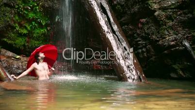 Man with umbrella at waterfall