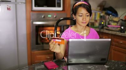 Woman shopping online in kitchen