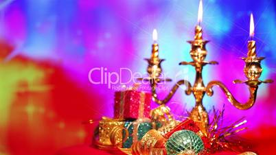 Christmas gift and candle on defocused lights background