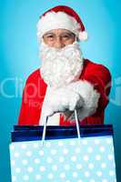 Santa holding shopping bags in his outstretched arms