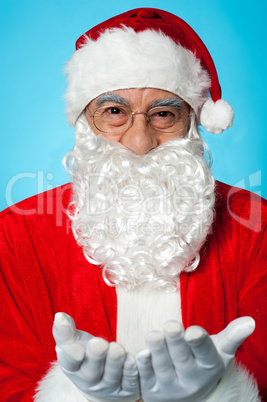 Smiling aged Santa posing with open palms