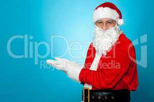 Santa against blue background posing with open palms