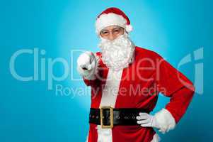 Handsome man in Santa costume pointing at you