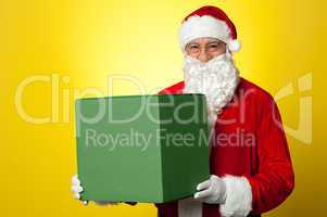 Santa Claus delivering big green gift box