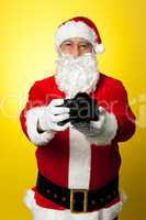 Santa Claus holding up his brand new DSLR