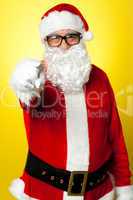 Jelly-belly Santa in spectacles pointing at you
