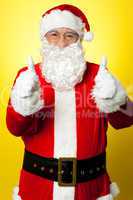 Cheerful male in Santa costume showing double thumbs up