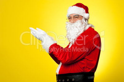 Side profile of Santa facing camera with open palms