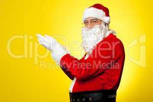 Side profile of Santa facing camera with open palms