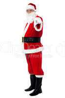 Senior man in Santa costume pointing at you