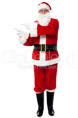 Man in Santa costume indicating at copy space area