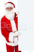 Aged Santa holding blank white banner ad board