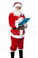 Santa Claus making list of gift recipients