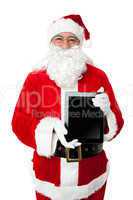 Old man in santa costume posing with a tablet pc