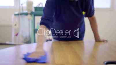 Woman working, professional maid cleaning and wiping table in office