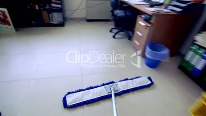 Timelapse of professional cleaner wiping floor with broom in office