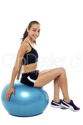 Pretty woman relaxing on big blue exercise ball