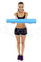 Woman holding a blue mat in her outstretched arms