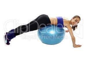 Woman lying over swiss ball to strengthen her abdomen
