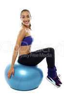 Pretty lady sitting on big blue exercise ball