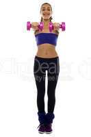 Woman holding pink dumbbells in her outstretched arms