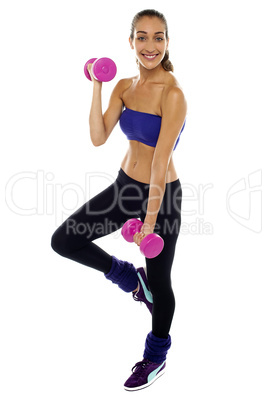 Slim young woman working out with dumbbells