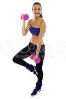 Slim young woman working out with dumbbells