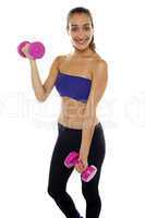 Middle aged woman posing with pink dumbbells