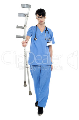 Sad doctor holding up crutches in hand