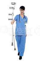 Orthopedic doctor walking towards camera with crutches in hand