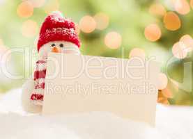 Cute Snowman with Blank White Card Over Abstract Background