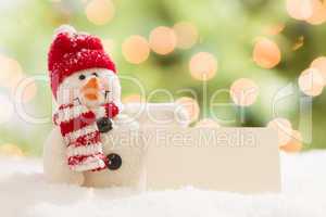 Cute Snowman with Blank White Card Over Abstract Background