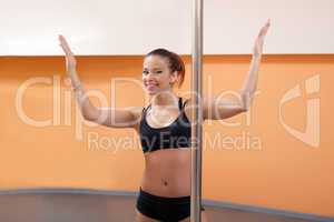 Young woman posing in pole dance training room