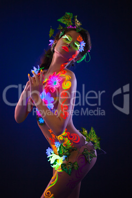 Beauty woman with glowing make-up posing in dark