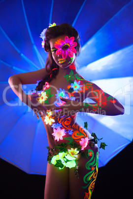 Sexy woman with uv glowing make-up posing nude